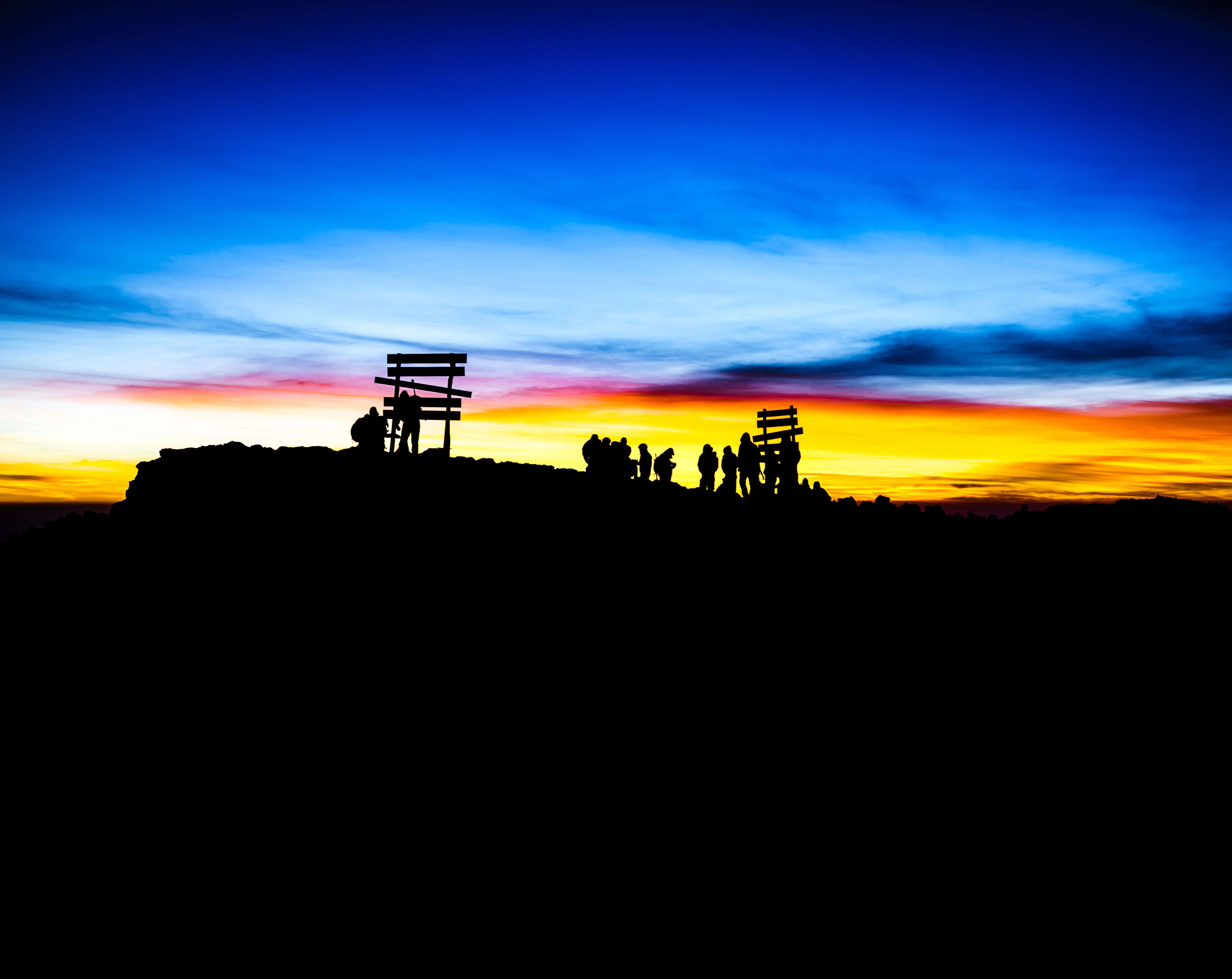 Adventurers gathered at a mountain summit at sunrise